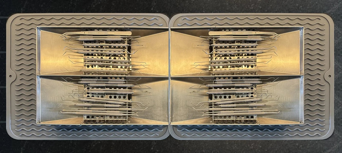 Two DriRak racks placed end to end on silicone mats, four instrument trays in one footprint